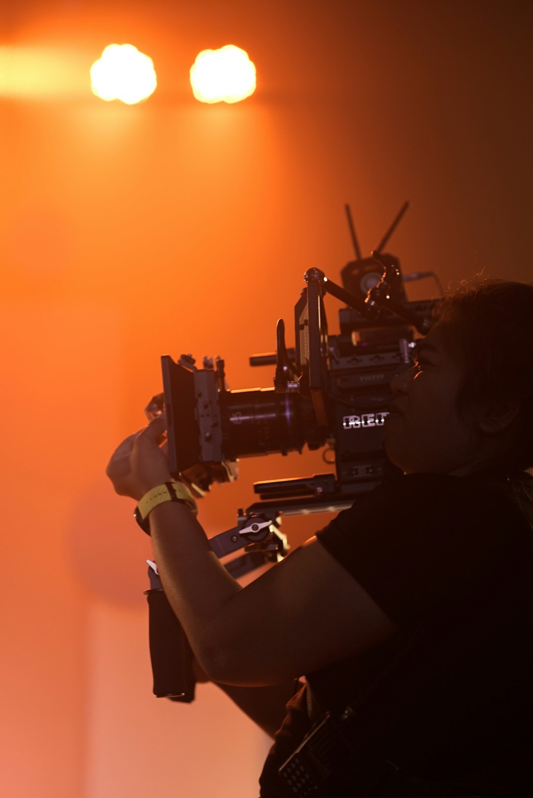 Camera operator filming a live event on a broadcast camera
